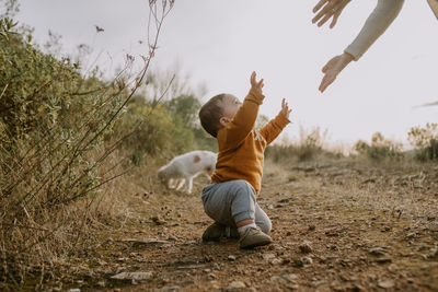 Rear view of boy with arms raised