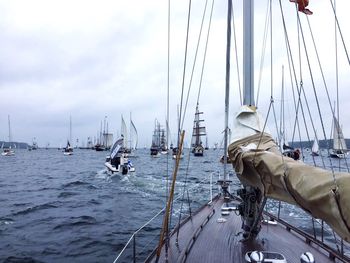 Boats moored at harbor against sky