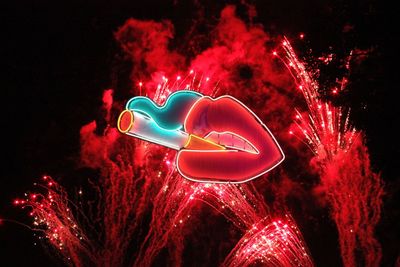 Low angle view of illuminated lighting equipment against black background