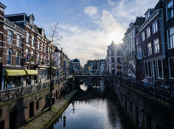 Canal amidst buildings in city against sky