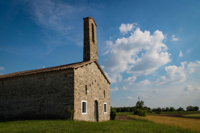 Old building on field against sky