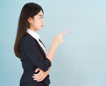 Side view of a young woman against white background