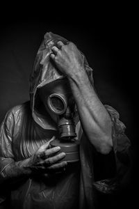 Close-up of man wearing gas mask in darkroom