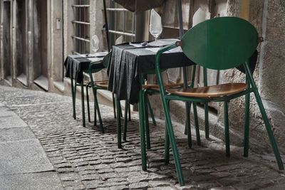 Empty chairs and table at sidewalk cafe