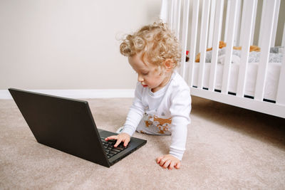  baby boy working on laptop. little kid child using technology. early age education development. 