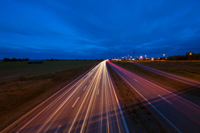 High angle view of light trails on multiple lane highway at night