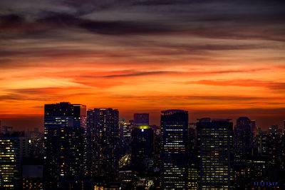 Illuminated buildings against sky during sunset