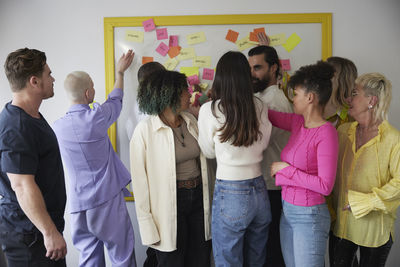 Diverse team standing in front of whiteboard during business meeting in conference room