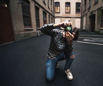 Full length of man photographing on street