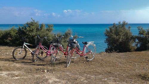 Bicycles on beach against sky