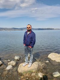 Full length of man standing on rock at lake