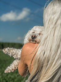 Close-up of woman with dog against sky