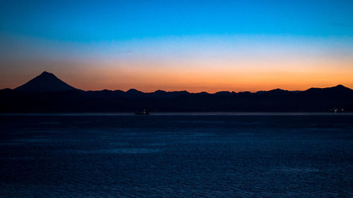 Scenic view of silhouette mountain against clear sky at sunset