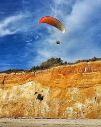 Person paragliding against sky