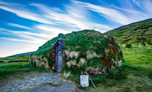 Built structure on field against sky