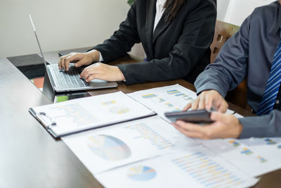 Midsection of business people working at office