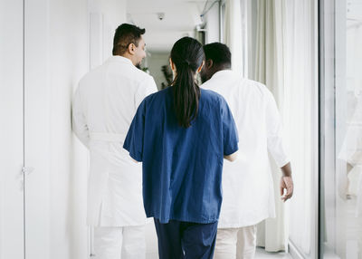 Rear view of multiracial healthcare team walking in corridor at hospital