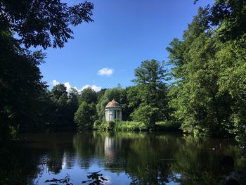 Scenic view of lake by trees against sky