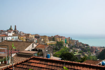 High angle view of townscape by sea against clear sky