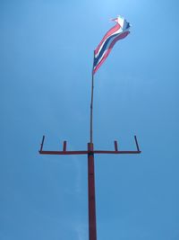Low angle view of flags against clear blue sky
