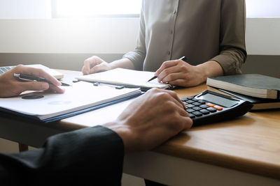 Midsection of businessman working at office