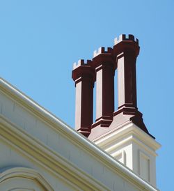 Low angle view of smoke stacks on parliament building against clear sky