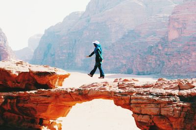 Full length of woman levitating against mountains