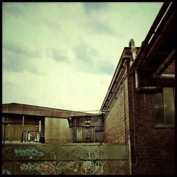 LOW ANGLE VIEW OF BUILT STRUCTURES AGAINST CLOUDY SKY