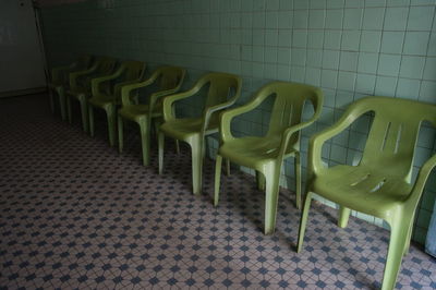 Empty chairs and table against wall