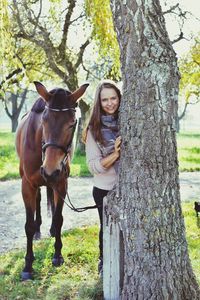 Portrait of girl with dog on tree trunk