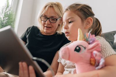 Grandmother and granddaughter using tablet pc at home