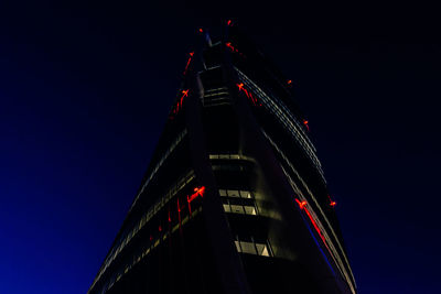 Low angle view of illuminated skyscraper against sky at night