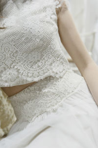 Midsection of woman wearing white dress