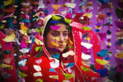 Bride looking away while sitting by decoration