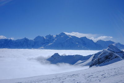 Scenic view of snowcapped mountains against blue sky