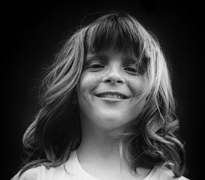 Portrait of young woman against black background