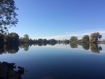 Scenic view of lake against clear blue sky