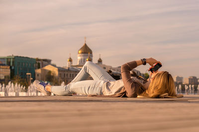 Surface level view of woman using mobile phone while lying on walkway against temple of christ the savior