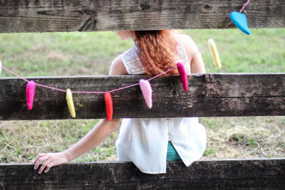 Woman sitting on wooden fence in a park. heart decorations for valentine's day. romantic, fairytale