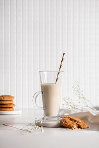 Glass of milk with homemade cookies on a white background. breakfast and healthy food concept