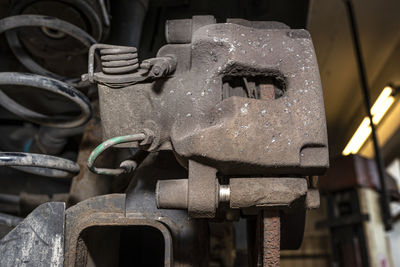 Old brake hose system, mounted to the car, close-up on the spring that tensions the handbrake.