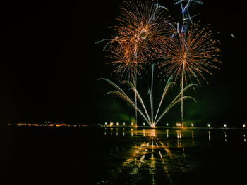 Illuminated firework display at night
