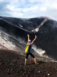 Full length of woman standing on mountain against sky