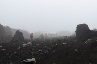 People on mountain against sky