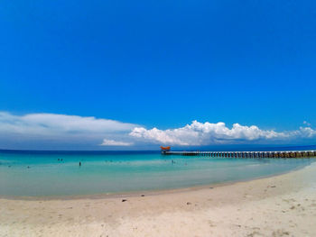 Scenic view of beach against blue sky