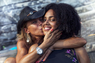 Portrait of mother kissing on daughter cheek