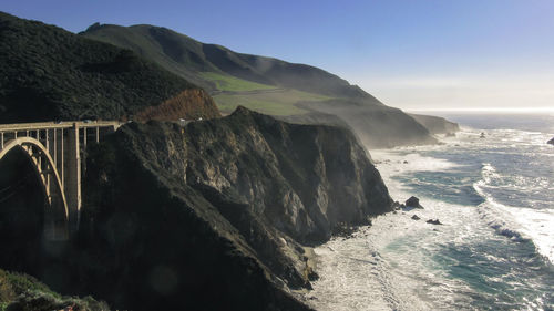 Scenic view of sea and mountains against clear sky