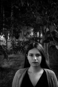 Portrait of young woman standing in park