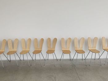 Empty chairs in row against clear sky