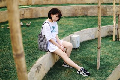 Full length of girl sitting on grass in park